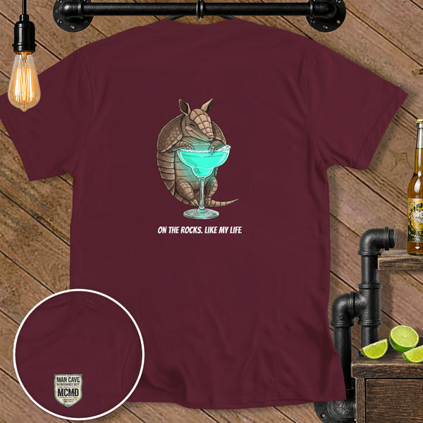 Maroon t-shirt with armadillo holding margarita and text "ON THE ROCKS, LIKE MY LIFE."