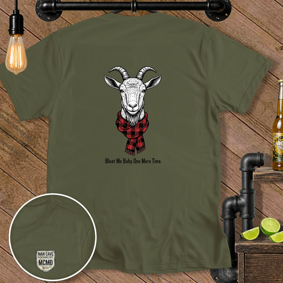 Olive green t-shirt with goat wearing scarf and text "Bleat Me Baby One More Time."