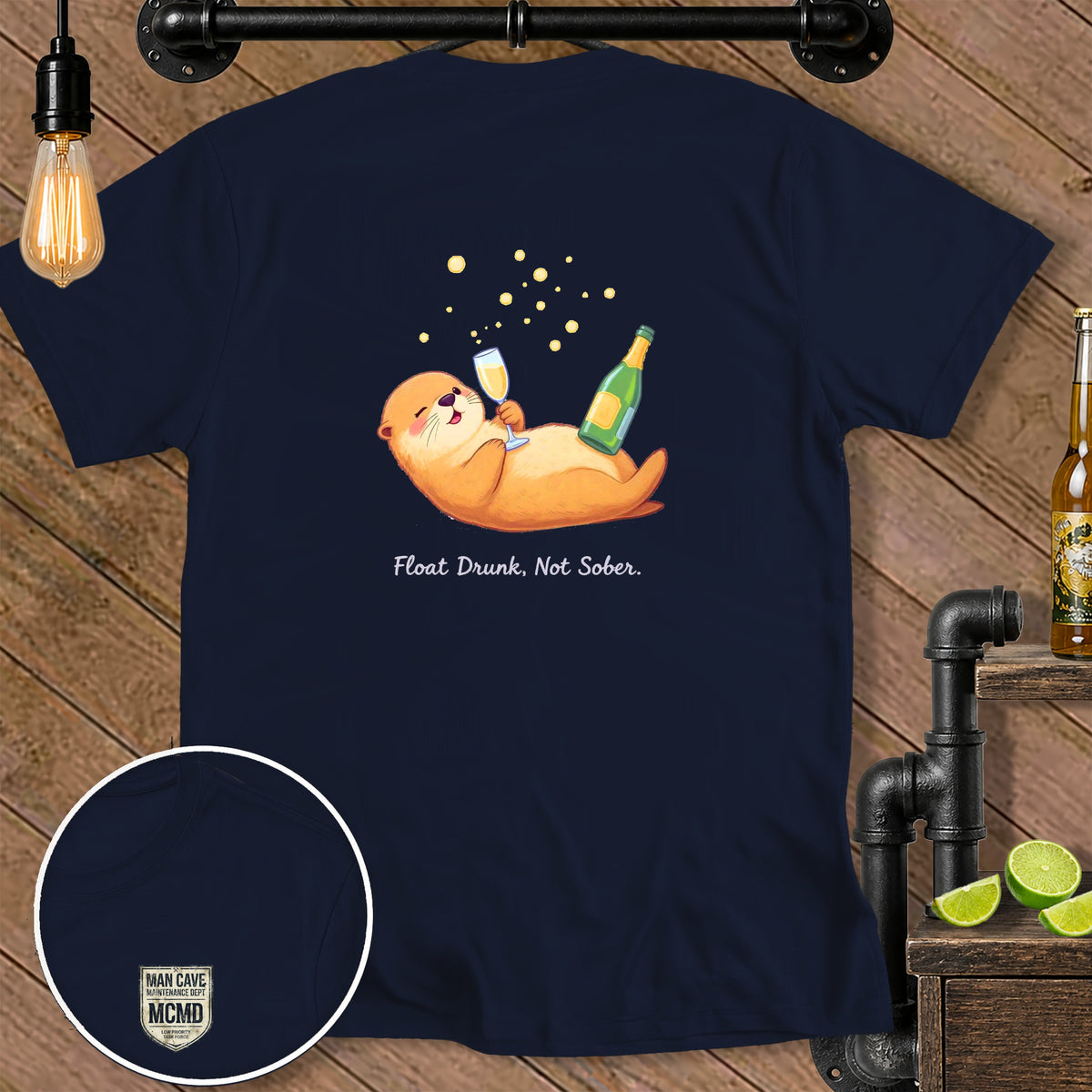 Navy t-shirt with otter holding champagne, text "Float Drunk, Not Sober."