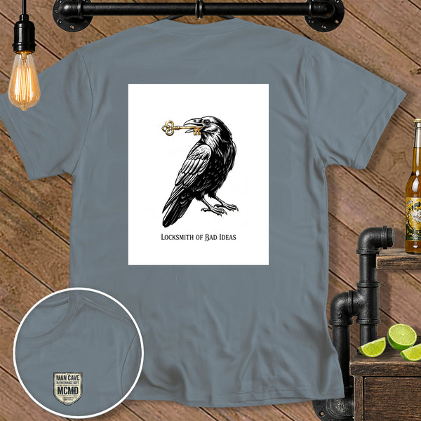 Gray t-shirt with a raven holding a key and the text "LOCKSMITH OF BAD IDEAS".