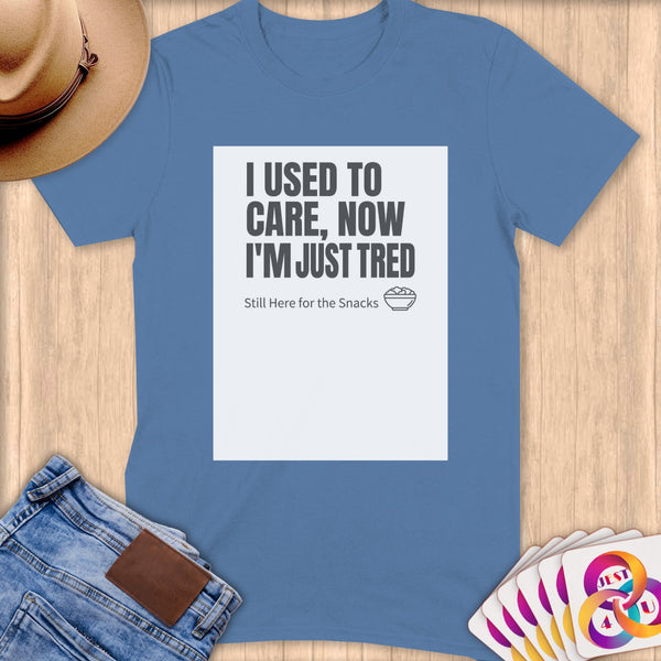 Blue t-shirt with text "I USED TO CARE, NOW I'M JUST TRED Still Here for the Snacks".