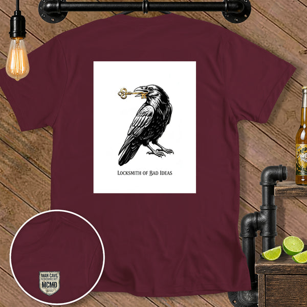 Maroon t-shirt with a crow holding a key and text "LOCKSMITH OF BAD IDEAS".