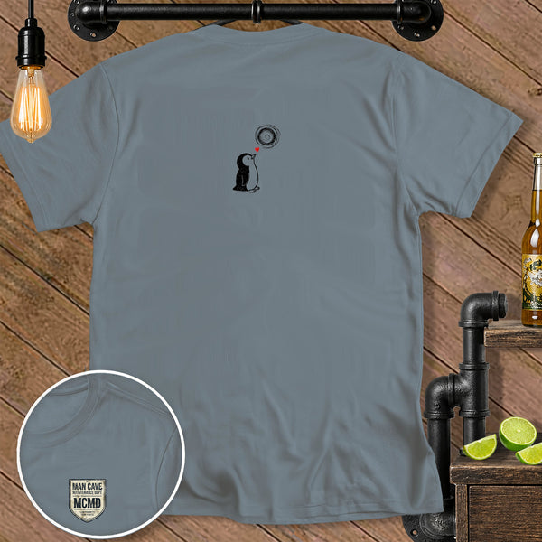 Grey t-shirt with a cartoon penguin graphic and a "MAN CAVE MCMD" badge.