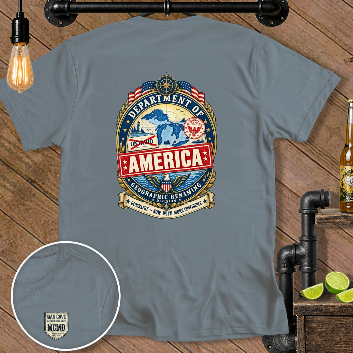 T-shirt with "Department of America Geographic Renaming Division" crest and "Man Cave Maintenance Dept MCMD" logo.