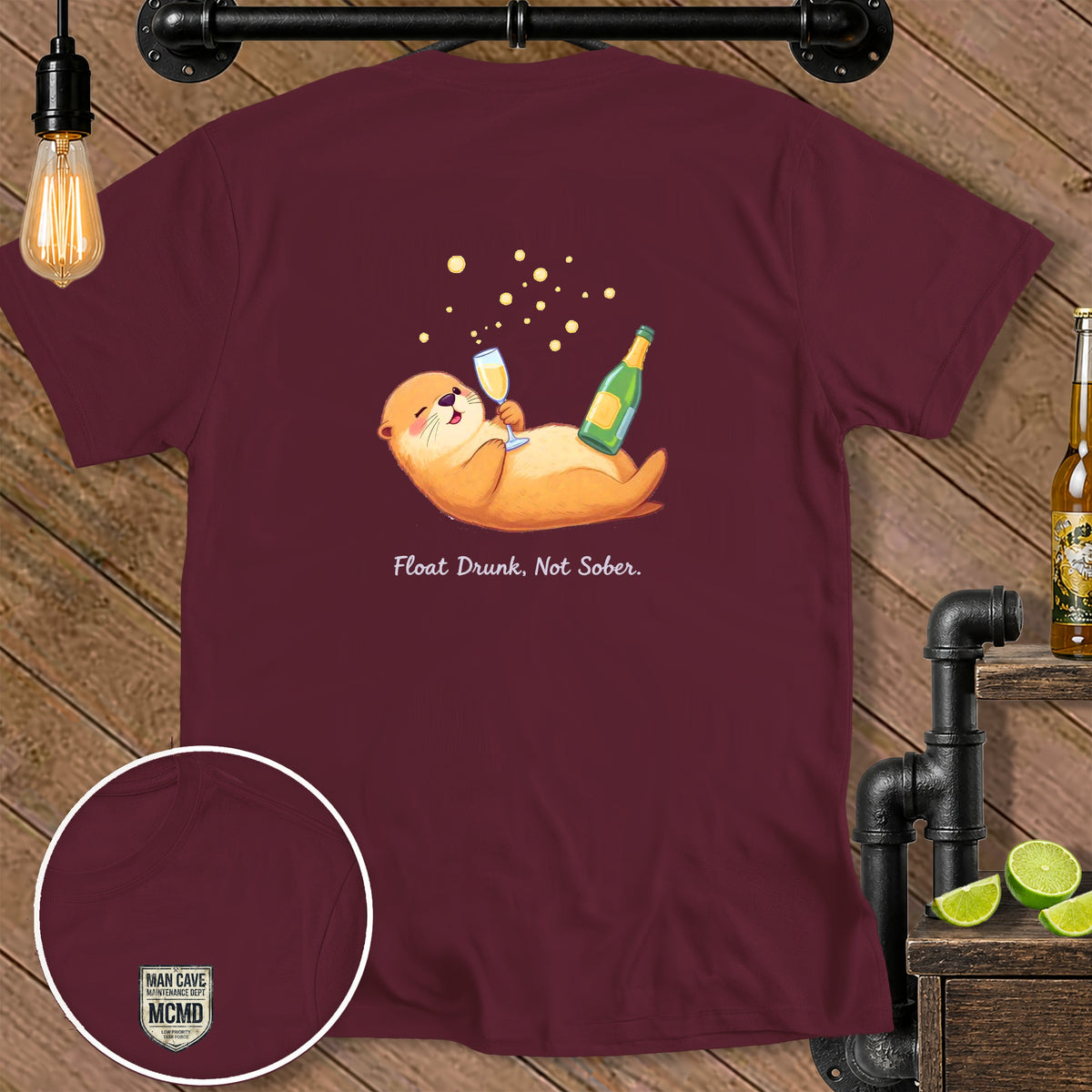 Maroon t-shirt with cartoon otter floating with champagne and text "Float Drunk, Not Sober."