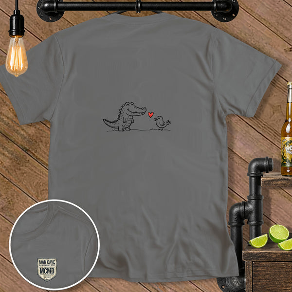 Grey t-shirt with cartoon alligator and bird illustration and "MAN CAVE MCMD" logo.