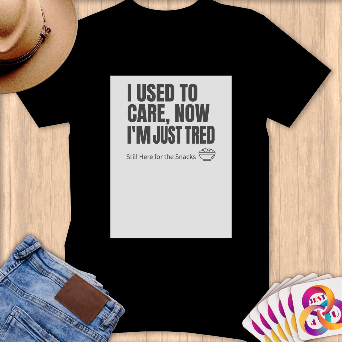 Black t-shirt with "I USED TO CARE, NOW I'M JUST TRED Still Here for the Snacks" text.