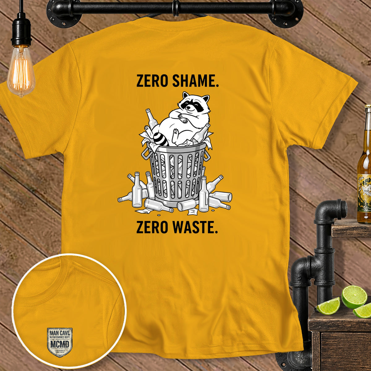 Yellow t-shirt with a raccoon in a trash can and bottles. Text reads "ZERO SHAME. ZERO WASTE."