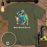 Olive green t-shirt with a colorful chameleon drinking a cocktail and text 