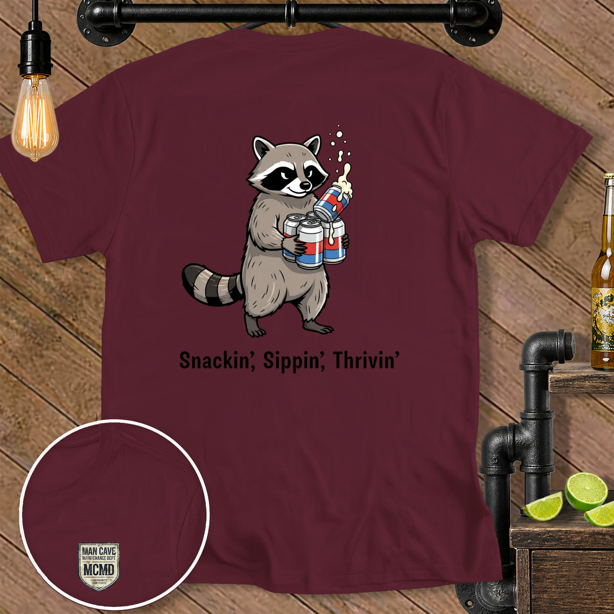 Maroon t-shirt with raccoon holding cans and text "Snackin', Sippin', Thrivin'".