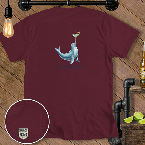 Maroon t-shirt with a seal balancing a margarita and text "Sealing the Buzz."