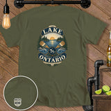 Green t-shirt with a badge graphic featuring a lake, sun, trees, and oars.
