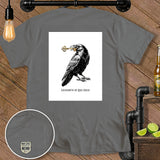 Gray t-shirt with a raven holding a key and text 