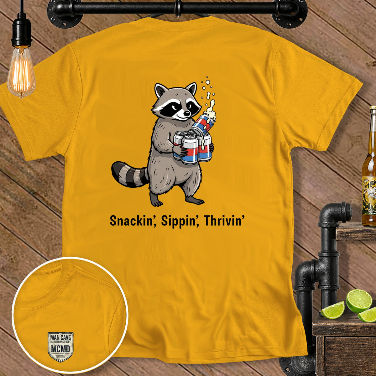Yellow t-shirt with raccoon holding cans, reads "Snackin', Sippin', Thrivin'".