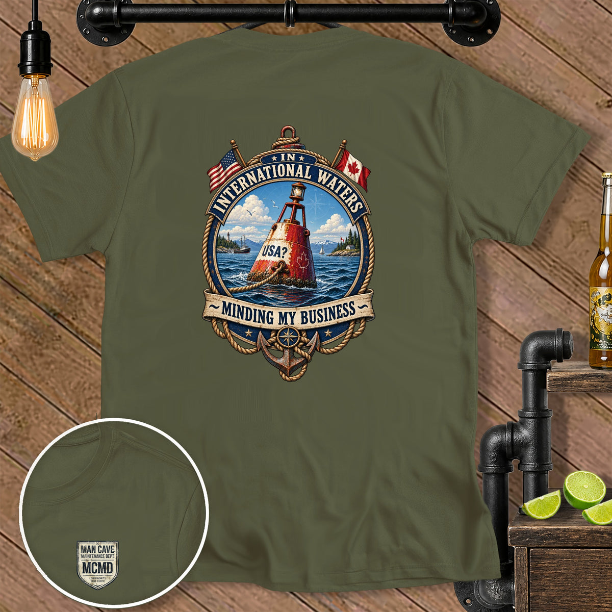 Olive green t-shirt with "International Waters Minding My Business" graphic and small chest logo.